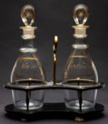 A pair of early 19th century 'Brandy' and 'Rum' decanters and stoppers in a brass mounted black