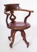 An Edwardian mahogany and studded leather swivel desk chair,