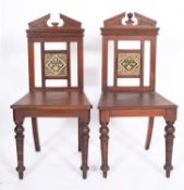 A pair of Victorian oak and glazed tile inset hall chairs, in Aesthetic Movement style,