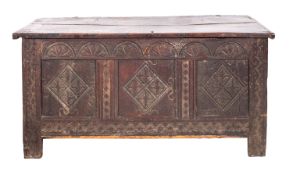 A Jacobean oak coffer, circa 1675; the front with frieze of relief carved lunettes,