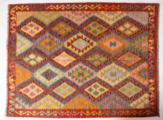 An Anatolian Turkish kelim, the brightly coloured field with serrated and hooked lozenge medallions,