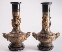 A pair of large Chinese carved soapstone vases and stands with mythical beast handles,