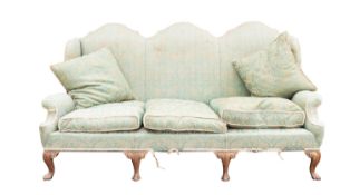 A Victorian carved walnut and upholstered three seat wing sofa in Queen Anne style,
