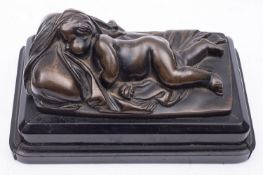 A Continental patinated bronze model of a sleeping putto,