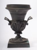 A small early 19th Century bronze pastille burner with angular handles and on square base,