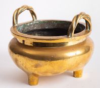 A large Chinese polished bronze tripod censer of compressed globular form with upright rope-twist