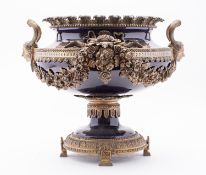 A large porcelain centrepiece bowl, of footed form with heavily cast brass mountings,