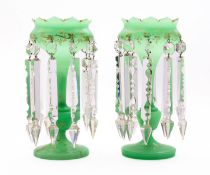 A pair of green glass lustres, with gilt decoration and hung with cut glass prisms and pendants,
