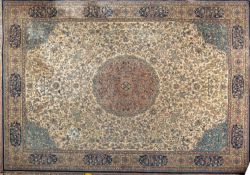 A machine made carpet of Kashan design, the ivory field with a central flowerhead medallion,