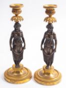 A pair of Empire patinated and gilt bronze figural candlesticks,