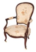 A Victorian carved walnut framed open armchair, circa 1860; the spoon back,