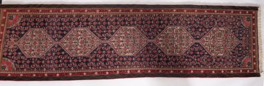A Senneh runner, the shaded field with a row of five ivory hexagonal medallions,