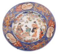 A Japanese Imari dish the centre decorated with bijin gardening within a phoenix border containing