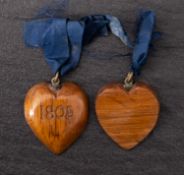 Two 19th century oak heart shaped pendants both inscribed 'Victory 1805' with blue ribbon