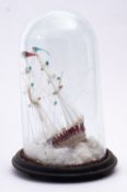 A 19th century glass frigger of a ship under glass dome, standing and running rigged,