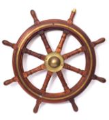 A teak and brass ship's helm.