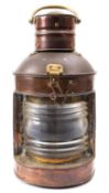 A copper and brass masthead lamp, unsigned, with original oil burner and reflector to interior,