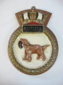 A wardroom badge for HMS Astute on wooden plinth: 25.