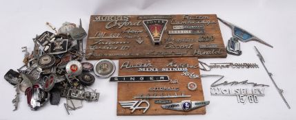 A collection of various mid 20th century car badges and name badges, including Jaguar, Austin,