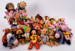 A collection of Disney 'Winnie The Pooh' soft toy figures in various costumes.