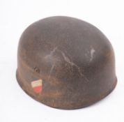 A WWII German Paratrooper's steel helmet, the exterior with remains of insignia,