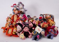 A collection of Disney 'Winnie The Pooh' soft toy figures in various costumes.