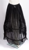 A late Victorian black cotton bustled underskirt (poor condition)