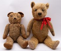 An early to mid 20th century blonde plush teddy bear, with glass eyes,