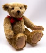 A late 20th century Harrods blonde plush Teddy bear, with glass eyes and hump-back,