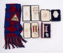 A group of four silver Masonic jewels in original boxes and Masonic sash.
