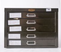Metal five drawer cabinet containing a quantity of coins, including £5 and £2 coins,