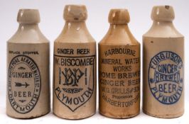 A collection of four Devon stoneware ginger beer bottles, Harbertonford, Dartmouth and two Plymouth,
