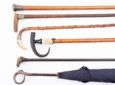 A silver topped walking cane, a silver topped lady's umbrella,
