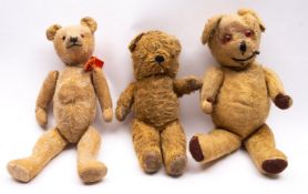An early to mid 20th century blonde plush teddy bear, with glass eyes,