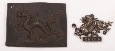 A white metal dragon badge inscribed 'China' together with a pressed metal form of a dragon 4x 5.