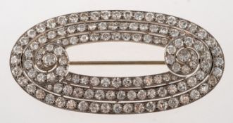 A fine Art Deco diamond brooch, of oval 'swirl' form with three rows of old-cut diamonds,