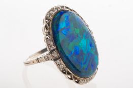 A black opal and diamond ring, an oval-cut black opal cabochon, measuring approx.