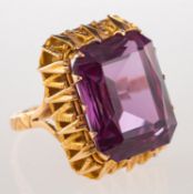 A cocktail ring, claw set in an openwork mount with a rectangular-cut synthetic purple sapphire,