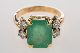 An emerald and diamond ring, claw set to the centre with a rectangular-cut emerald, emerald approx.