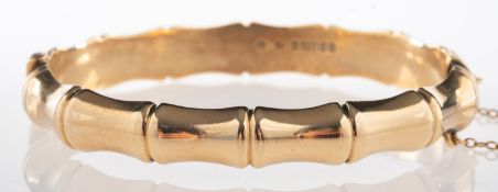 A 9ct gold 1960's bamboo design bangle, hinged with a push-in clasp and safety chain, UK hallmark,