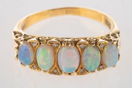 An 18ct gold opal and diamond scroll ring, set with five opal cabochons,
