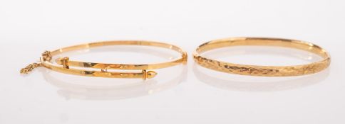 A group of two bangles, including a 9ct gold hammered finish bangle, hinged, UK import mark,