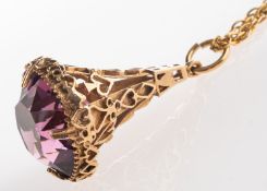 A fob pendant and chain, an ornate fob pendant set with a circular-cut purple paste stone,