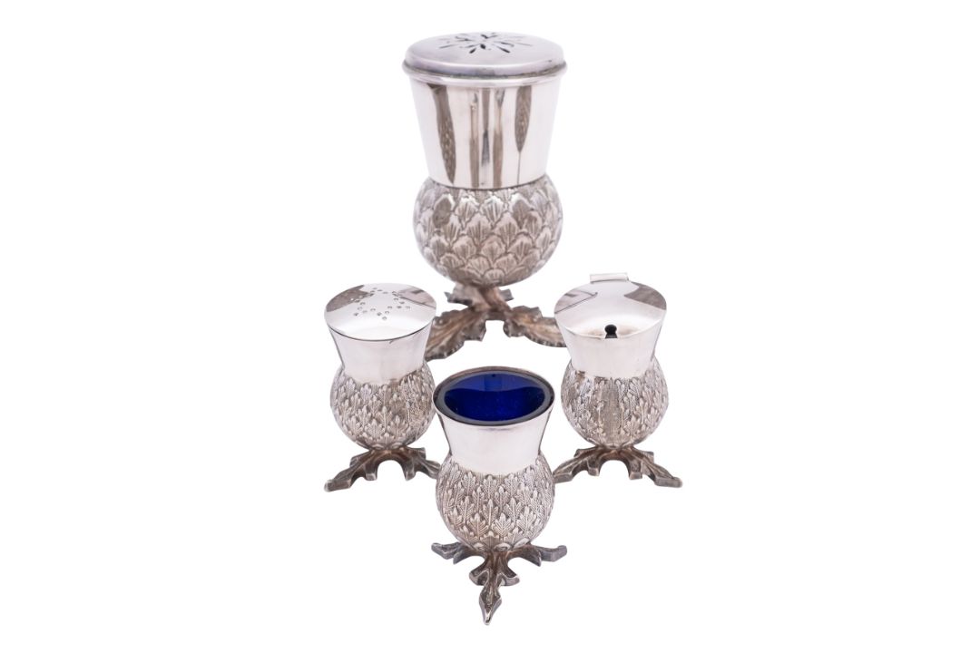 A four piece silver plated cruet set in the shape of thistles,