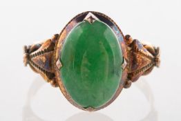 A jade ring, an oval-cut jade cabochon in an ornately carved shoulder ring, marked 14k,