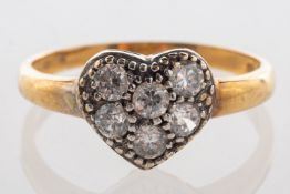 A 9ct gold heart-shaped ring, set with six clear paste stones, UK import mark, size P, 2.0grams.
