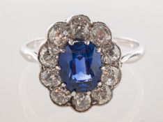 An oval synthetic sapphire and diamond cluster ring, claw set with an oval-cut synthetic sapphire,