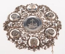 A Scandinavian brooch, of open filigree work with seven silver discs depicting different symbols,