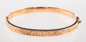 A flower and foliate engraved bangle, hinged, marked 9ct, makers mark S&P, inner diameter approx. 5.
