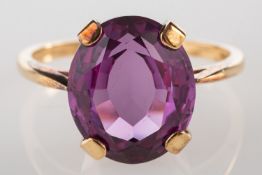 A 9ct gold single stone ring, claw set with an oval-cut synthetic purple sapphire, approx. 5.